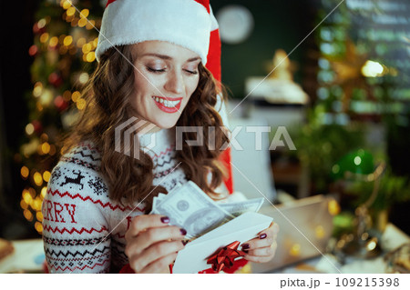 smiling business woman in green office with Christmas tree 109215398