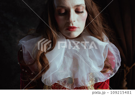 medieval queen in red dress with white collar 109215481