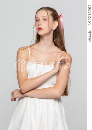 Portrait of a cute romantic young seventeen year old girl on a gray background. 109216306