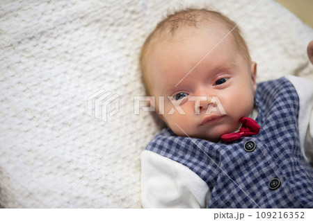 The face of a newborn baby in a real environment. 109216352