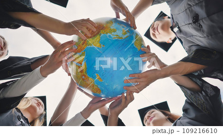 Graduating students twirl a geographic globe of the world in their hands. Graduating students twirl a geographic globe of the world in their hands. 109216610
