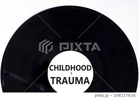Childhood trauma symbol. Concept words Childhood trauma on beautiful black vinyl disk. Beautiful white table white background. Business psychology childhood trauma concept. Copy space. 109217616