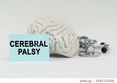 On a white surface next to the brain there is a stethoscope and stickers with the inscription - CEREBRAL PALSY On a white surface next to the brain there is a stethoscope and stickers with the inscription - CEREBRAL PALSY 109218388