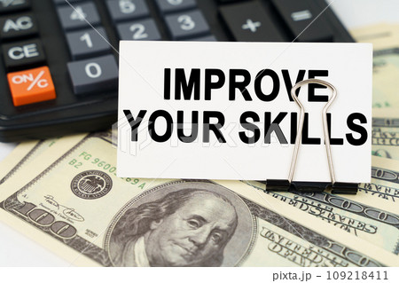 On the dollars there is a calculator and a business card with the inscription - IMPROVE YOUR SKILLS On the dollars there is a calculator and a business card with the inscription - IMPROVE YOUR SKILLS 109218411
