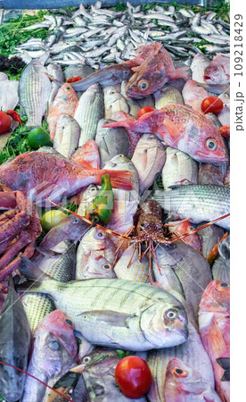 Stall at the Essaouira fish market with a variety of fresh seafood. Fishermen skillfully clean and prepare the catch, offering the coastal traditions that define Essaouira's culinary culture. 109218429