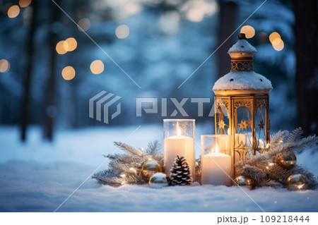 An outdoor winter scene with a lantern, candles, and holiday ornaments in the snow. Generative AI 109218444
