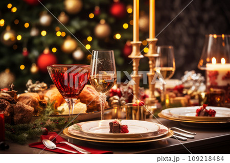 A holiday table setting with glasses of wine, candles, and a Christmas tree in the background. Generative AI 109218484