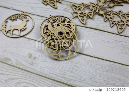Flat wooden toy in the shape of a circle with a pattern for decorating a Christmas tree for the New Year Flat wooden toy in the shape of a circle with a pattern for decorating a Christmas tree for the New Year 109218495
