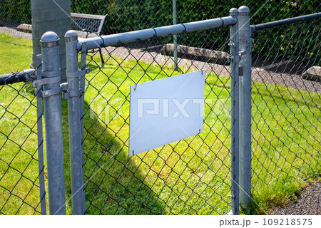 Blank white signboard on a chain link fence in a park Blank white signboard on a chain link fence in a park 109218575