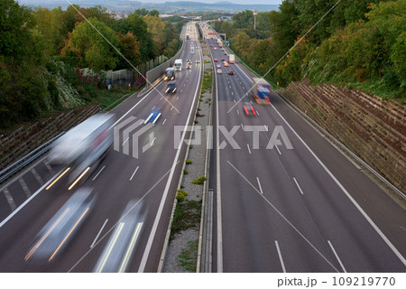 Night lights from car headlights on roundabout in night city. Traces of headlights on the road at night, long exposure. Drone aerial shot. Panoramic aerial view of illuminated road overpass and road 109219770
