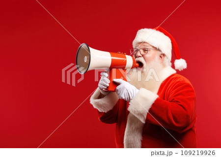 Santa Claus with megaphone on red background. Santa Claus with megaphone on red background. 109219926
