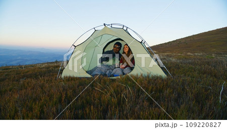 African American man kisses Caucasian woman, closes enter of tent African American man kisses Caucasian woman, closes enter of tent 109220827