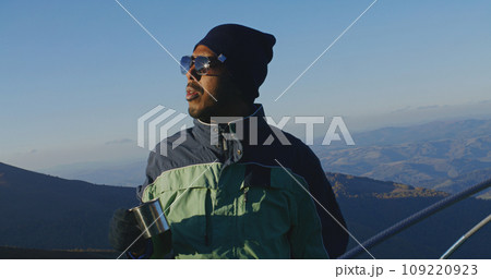 Tourist drinks cup of tea on top of mountain hill 109220923