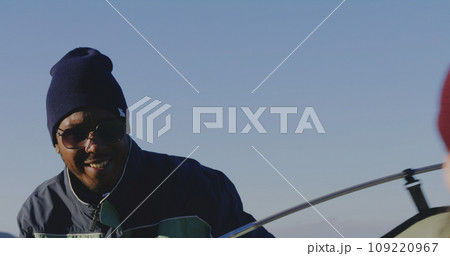 African American man sets up tent on mountain 109220967
