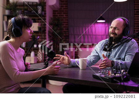 Show host interviewing woman during live stream, talking about fashion and style trends, disagreeing with her opinions. Man arguing with social media celebrity, recording podcast Show host interviewing woman during live stream, talking about fashion and style trends, disagreeing with her opinions. Man arguing with social media celebrity, recording podcast 109222081