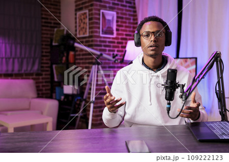 Content creator broadcasting live on streaming platform from vibrant neon lights home studio using professional equipment producing high quality audio. Vlogger creating engaging social media content Content creator broadcasting live on streaming platform from vibrant neon lights home studio using professional equipment producing high quality audio. Vlogger creating engaging social media content 109222123
