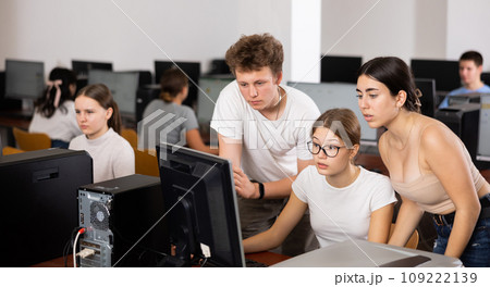 Clever teenagers helping to the female classmate while she is learning computer science in the class 109222139
