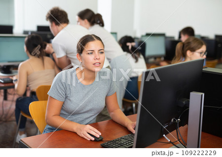 Surprised girl student sitting at her workplace and studying in computer class Surprised girl student sitting at her workplace and studying in computer class 109222229
