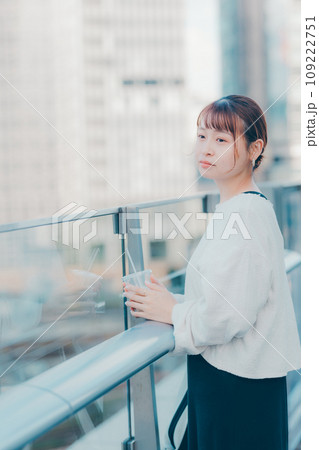 外でコーヒーを飲む若い女性 109222751