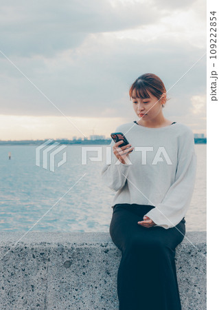 海辺で音楽を聴く女性 109222854
