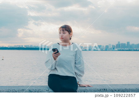 海辺で音楽を聴く女性 109222857