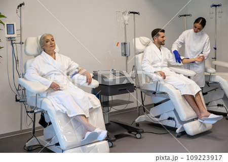 Woman and man in wellness center during intravenous vitamin therapy. 109223917