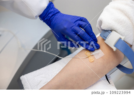 Woman receiving vitamin IV infusion drip in wellness center or beauty salon. Woman receiving vitamin IV infusion drip in wellness center or beauty salon. 109223994