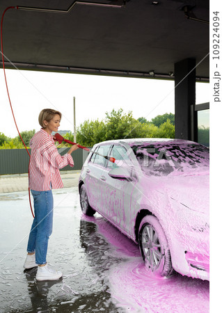 Woman cleaning a white car the car wash 109224094