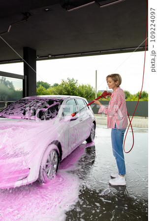Woman cleaning a white car the car wash Woman cleaning a white car the car wash 109224097