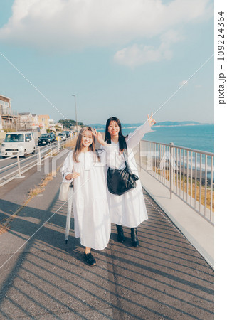 海辺で散歩している若い女性2人 109224364