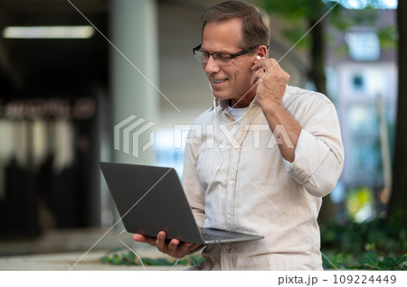 Man having video call online with laptop computer outdoor. 109224449