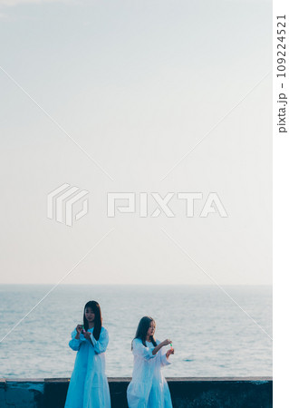 海辺でシャボン玉をしている若い女性2人 海辺でシャボン玉をしている若い女性2人 109224521