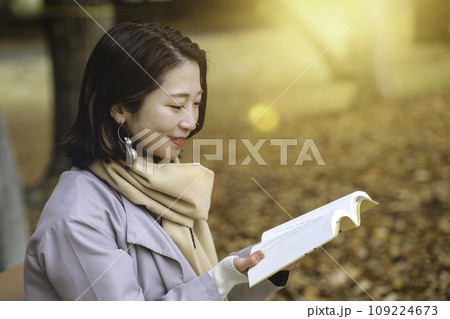 紅葉の公園のベンチで読書をする女性 紅葉の公園のベンチで読書をする女性 109224673