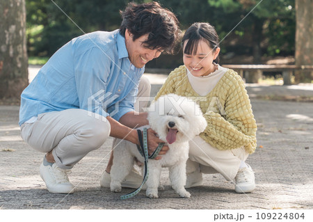 愛犬を可愛がる飼い主の親子・犬の散歩(父親と娘) 愛犬を可愛がる飼い主の親子・犬の散歩(父親と娘) 109224804