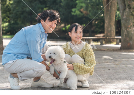 愛犬を可愛がる飼い主の親子・犬の散歩（父親と娘） 109224807