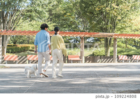 愛犬を可愛がる飼い主の親子・犬の散歩(父親と娘) 愛犬を可愛がる飼い主の親子・犬の散歩(父親と娘) 109224808