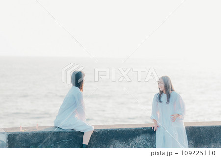 海辺で会話をしている若い女性2人 109225110