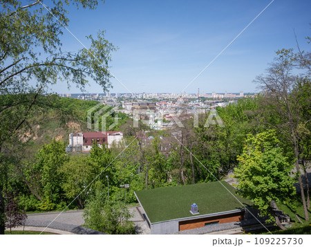 【ウクライナ】首都キーウの緑に覆われた自然公園越しに望む都会の街並みと快晴の青空 109225730
