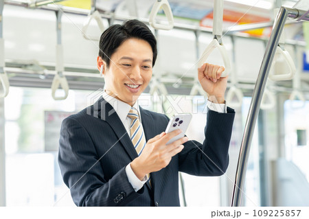 通勤電車でスマホを見るミドルのビジネスマン 撮影協力「京王電鉄株式会社」 通勤電車でスマホを見るミドルのビジネスマン 撮影協力「京王電鉄株式会社」 109225857