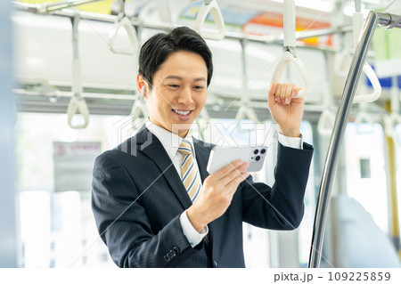 通勤電車でスマホを見るミドルのビジネスマン 撮影協力「京王電鉄株式会社」 通勤電車でスマホを見るミドルのビジネスマン 撮影協力「京王電鉄株式会社」 109225859
