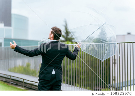 雨の日に傘をさす外国人ビジネスマン(梅雨・台風・雨上がり・異常気象) 雨の日に傘をさす外国人ビジネスマン(梅雨・台風・雨上がり・異常気象) 109225976