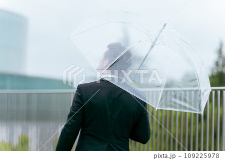 雨の日に傘をさす外国人ビジネスマン(梅雨・台風・異常気象・天候) 雨の日に傘をさす外国人ビジネスマン(梅雨・台風・異常気象・天候) 109225978