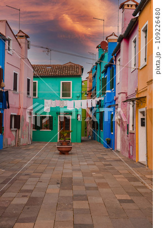 Discover the charming, colorful streets of Burano, Venice. This photo captures the traditional Venetian architecture and vibrant hues of the buildings, creating a peaceful and serene atmosphere. 109226480