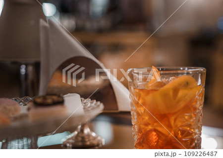 Close-up of an old-fashioned cocktail in an unspecified glass on a table. Part of a collection of Venice photos showcasing popular places and luxury interiors in real Venetian style. 109226487