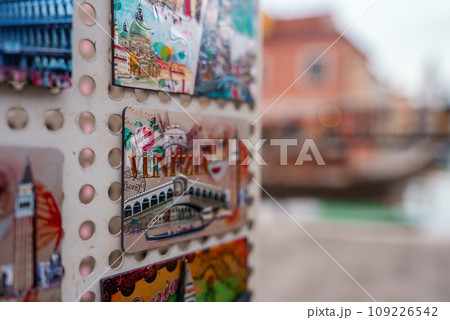 Colorful and vibrant display of postcards on a wall in Venice, Italy. The random pattern showcases popular landmarks and aspects of Venetian culture, capturing the city's unique charm and beauty. 109226542
