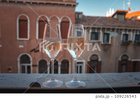 Enjoy a tranquil evening with a city view from this luxury balcony. Two wine glasses rest on the ledge, creating a serene atmosphere perfect for relaxation and unwinding. Enjoy a tranquil evening with a city view from this luxury balcony. Two wine glasses rest on the ledge, creating a serene atmosphere perfect for relaxation and unwinding. 109226543