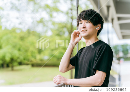 スポーツ・トレーニング中にワイヤレスイヤホンで音楽を聴く・ハンズフリーイヤホンを使う男性 109226665