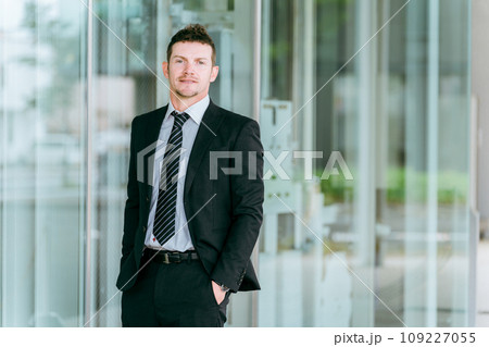 ビルの前に立つ欧米人ビジネスマン・海外出張・海外赴任・商社・貿易 109227055