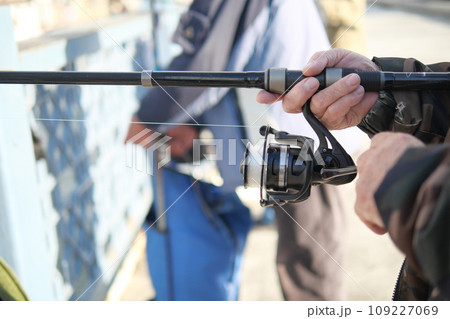 Fisherman with rod, spinning reel , 109227069