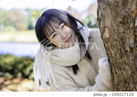 秋冬の公園を散策する若い女性 109227128